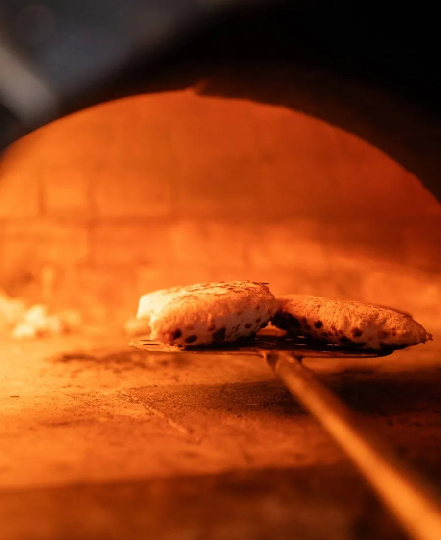 Cuisson d’une pizza au feu de bois chez ZE KIFF