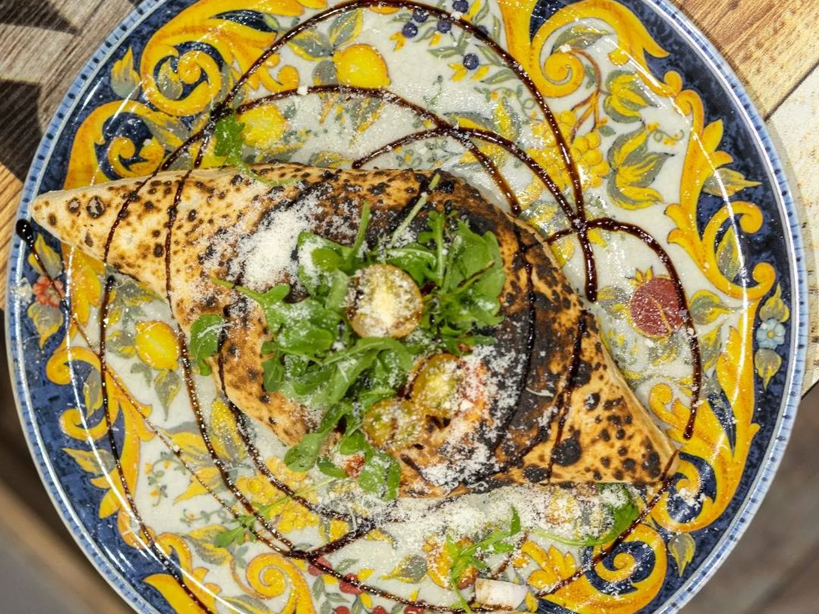 Pizza de ZE KIFF garnie de roquette, charcuterie et fromage